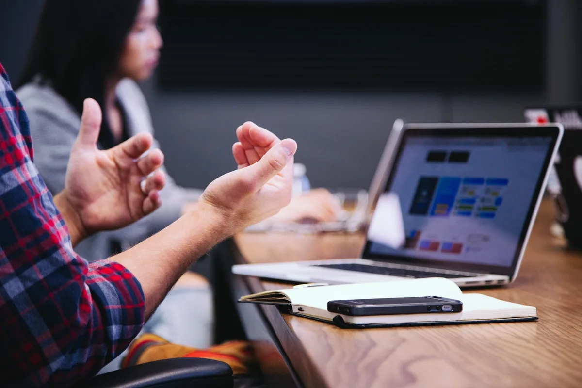 Komanda aptaria idėjas prie kompiuterio ir užrašų